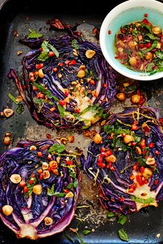 cabbage and chickpeas on a baking sheet with a bowl of dressing next to it