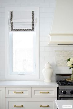 a white kitchen with gold handles and drawers