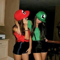 two young women dressed up in mario and luigi hats, standing next to each other