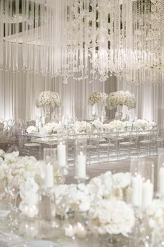 the tables are set with white flowers and candles