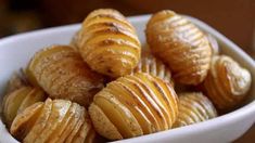 a white bowl filled with sliced potatoes on top of a table