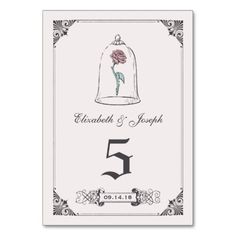 a wedding table card with a bell and rose on the front, in black ink