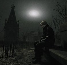 a man sitting on a bench in the dark