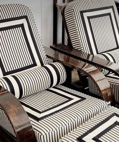 two chairs sitting next to each other on top of a wooden floor covered in black and white stripes