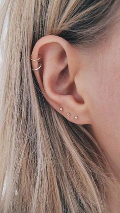 a woman's ear with two piercings on it, and the top half of her ear is shown