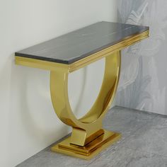 a marble and gold console table against a wall