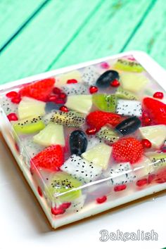 a square glass dish filled with fruit on top of a table