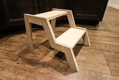 a wooden step stool sitting on top of a hard wood floor