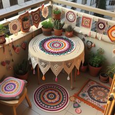 a small balcony with potted plants and rugs on the balconied area