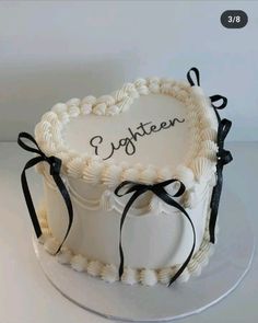 a heart shaped cake with the words eighteen written on it and ribbon around the edges