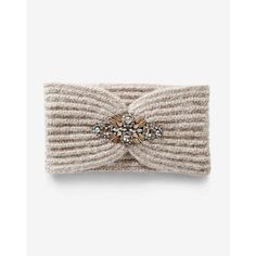 a knit headband with a bow and crystal brooch on the front in beige