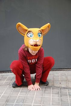 a person wearing a cat mask on the ground