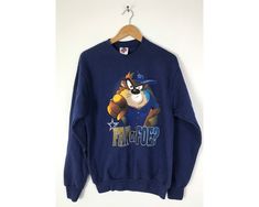 "-Description- >1995 Tasmanian Devil Dallas Cowboys fan or foe sweatshirt >crew neck pullover >size medium >perfect for a Cowboys fan! >condition: great >color(s): blue, brown, black, white >fabric(s): 50 cotton / 50 polyester >brand: league leader >care: machine wash -Measurements- >size: medium ✩ all measurements are taken with the item laying flat & some sizes are estimates so please check measurements ✩ chest: 39\" / 99cm length: 27\" / 68cm shoulder to slee Retro Long Sleeve Sweatshirt For Fans, Vintage Crew Neck Sweatshirt For Fans, Vintage Crew Neck Hoodie, 90s Style Winter Sweatshirt For Fans, Hip Hop Style Long Sleeve Sweatshirt For Fans, Vintage Graphic Print Sweatshirt For Fans, Throwback Crew Neck Hoodie For Fan Merchandise, 90s Style Graphic Print Sweatshirt For Fans, Throwback Fan Merchandise Sweatshirt For Sports Season