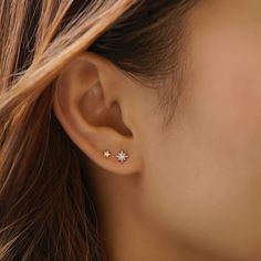 a woman's ear is shown with two small stars in the middle of it