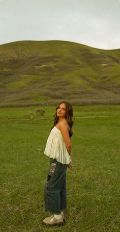 a woman standing in the middle of a field