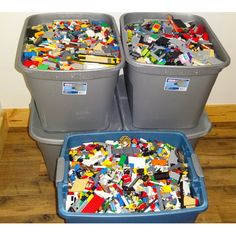 three bins filled with different types of legos on top of a wooden floor