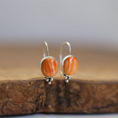 These are wonderful orange, spiny oyster drop earrings. Just that perfect pop of red/orange you want - perfect! This is the Piper Earring design, and we couldn't love it more than in this fabulous, orange Spiny Oyster. Modern and traditional at the same time! Minimal embellishments except for the trio of sterling silver beads - just enough to add mystique to these poppy red Spiny Oyster Shell. All .925 Sterling Silver - oxidized, sanded, and burnished to the perfect finish. Easy on and squeeze a Orange Teardrop Sterling Silver Earrings, Handmade Sterling Silver Orange Earrings, Handmade Orange Sterling Silver Earrings, Orange Gemstone Dangle Earrings, Orange Gemstone Drop Earrings, Orange Teardrop Gemstone Earrings, Coral Earrings For Gift, Orange Gemstone Sterling Silver Earrings, Unique Oval Orange Jewelry