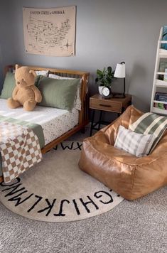 a child's bedroom with a teddy bear on the bed and a rocking chair