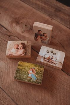 three small boxes with photos on them sitting on top of a wooden table next to an open box