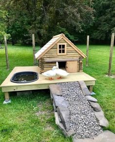 a duck house built on top of a wooden platform