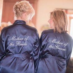 two women in blue robes are looking at each other with their backs to the camera