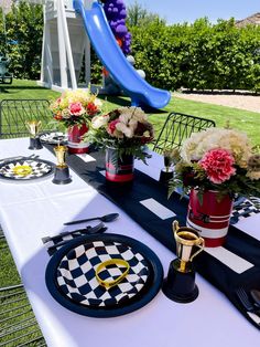 Formula 1 themed tablescape, formula 1 kids table setup, race car setup, checkered plates, trophy props, kids table with white chairs and white linen, oil can centerpieces with red and white florals and greenery, paradise valley arizona Formula 1 Birthday, 1 Birthday Party, Ferrari Party, Cars Birthday Party Decorations, Paradise Valley Arizona, Backyard Birthday Parties, Boys Birthday Party, Backyard Birthday