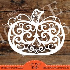 pumpkin cutout with swirly designs on wood background