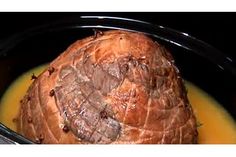 a close up of a meat in a crock pot with broth on the side