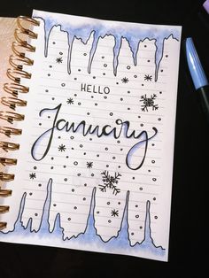 a notebook with the word january written on it next to a pen and some markers