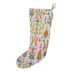 a white christmas stocking with colorful flowers and trees on the bottom, hanging from a rope