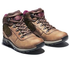 a pair of brown hiking boots with purple laces on the outstretches