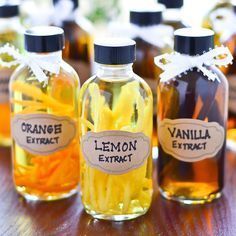 several bottles filled with liquid sitting on top of a wooden table next to each other