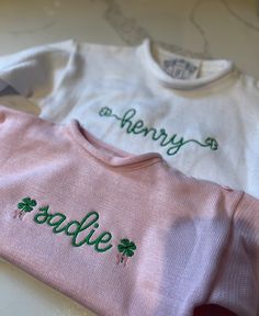 two personalized shirts with shamrocks on them sitting on a counter top next to each other