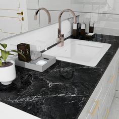 a bathroom sink sitting under a mirror next to a potted plant on top of a counter