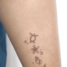 a small tattoo on the leg of a woman with stars and planets around her body