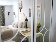 an image of a bedroom with mirrored doors in the door way and flowers on the table