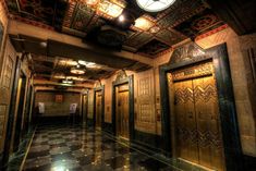 the elevators are all lined up in an ornately decorated room with black and gold tile flooring