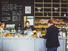 two men standing at a counter in a bakery