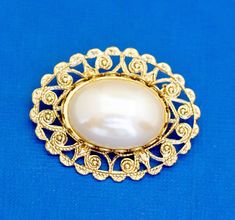 For sale is a gold tone oval-shaped brooch with faux pearl.    Shipping:  I'll ship out your item either the same day or the next day depending on what time you order. Most items will be placed in a jewelry box and shipped USPS first class in a bubble mailer.  Keywords:  Vintage Brooch, Victorian Brooch, White Faux Pearl Brooch, Gold Tone Brooch, Oval Brooch, Elegant Brooch Elegant Brooch, Victorian Brooch, Imperial Russia, Bubble Mailer, Pearl Brooch, Vintage Brooch, Vintage Brooches, Faux Pearl, Favorite Jewelry