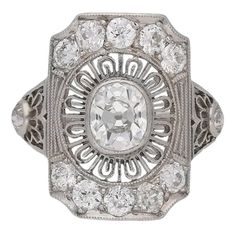 an antique diamond ring with filigrees on the sides and center surrounded by smaller round diamonds