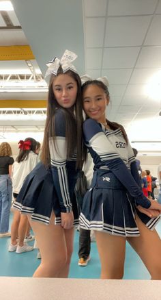 two girls in cheer uniforms posing for the camera