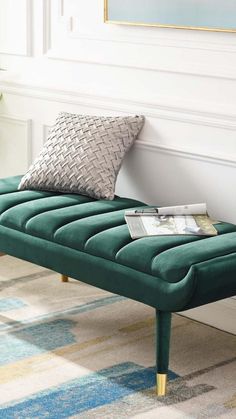 a green bench sitting on top of a rug next to a potted plant