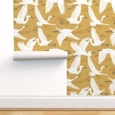 the wall paper is designed with white birds on yellow background, and has an interesting pattern