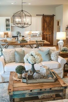 a living room filled with lots of furniture and flowers on top of a coffee table