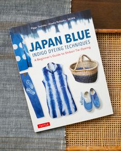 the book japan blue is sitting on top of a woven basket and it's contents