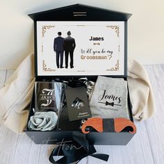 an open gift box containing personal items for a groom and his best man, with a card in it