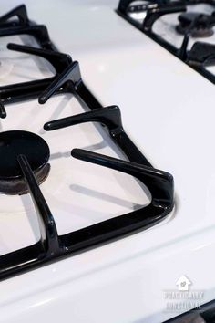 a white stove top with black burners on it