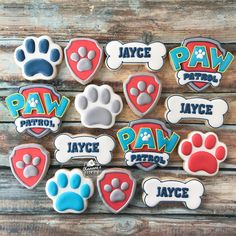 paw patrol cookies are displayed on a wooden table with the words paw patrol written in different languages