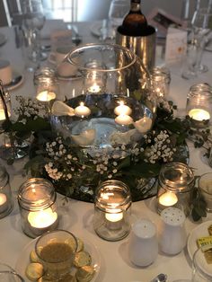 a table topped with lots of candles and plates