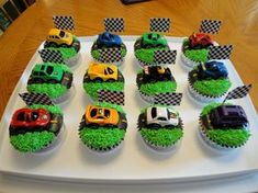 cupcakes decorated with cars and grass on a tray